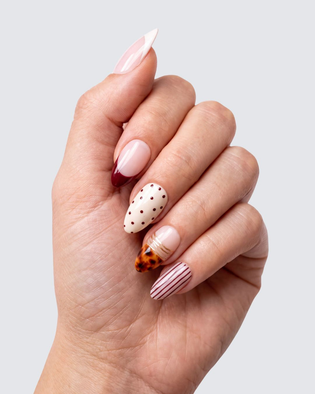 Saint Germain press on nails, glossy almond mix with cream and burgundy french tips, polka dots, pinstripes and gold leopard